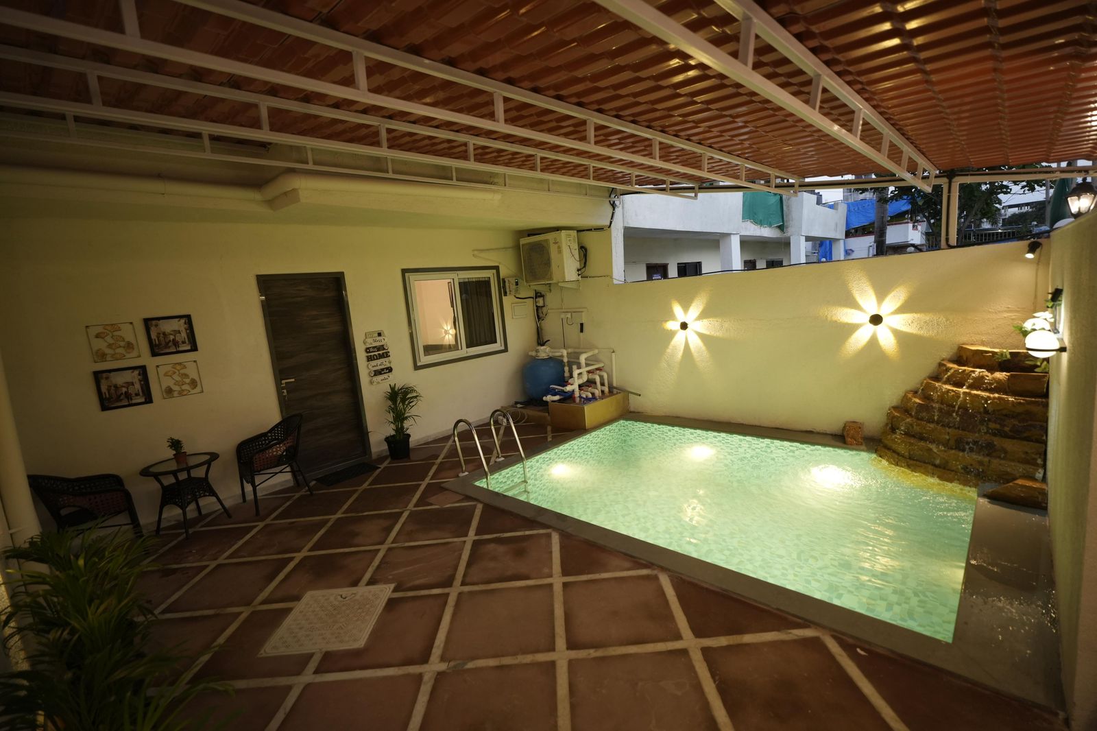 Private pool with cascading water feature at night
