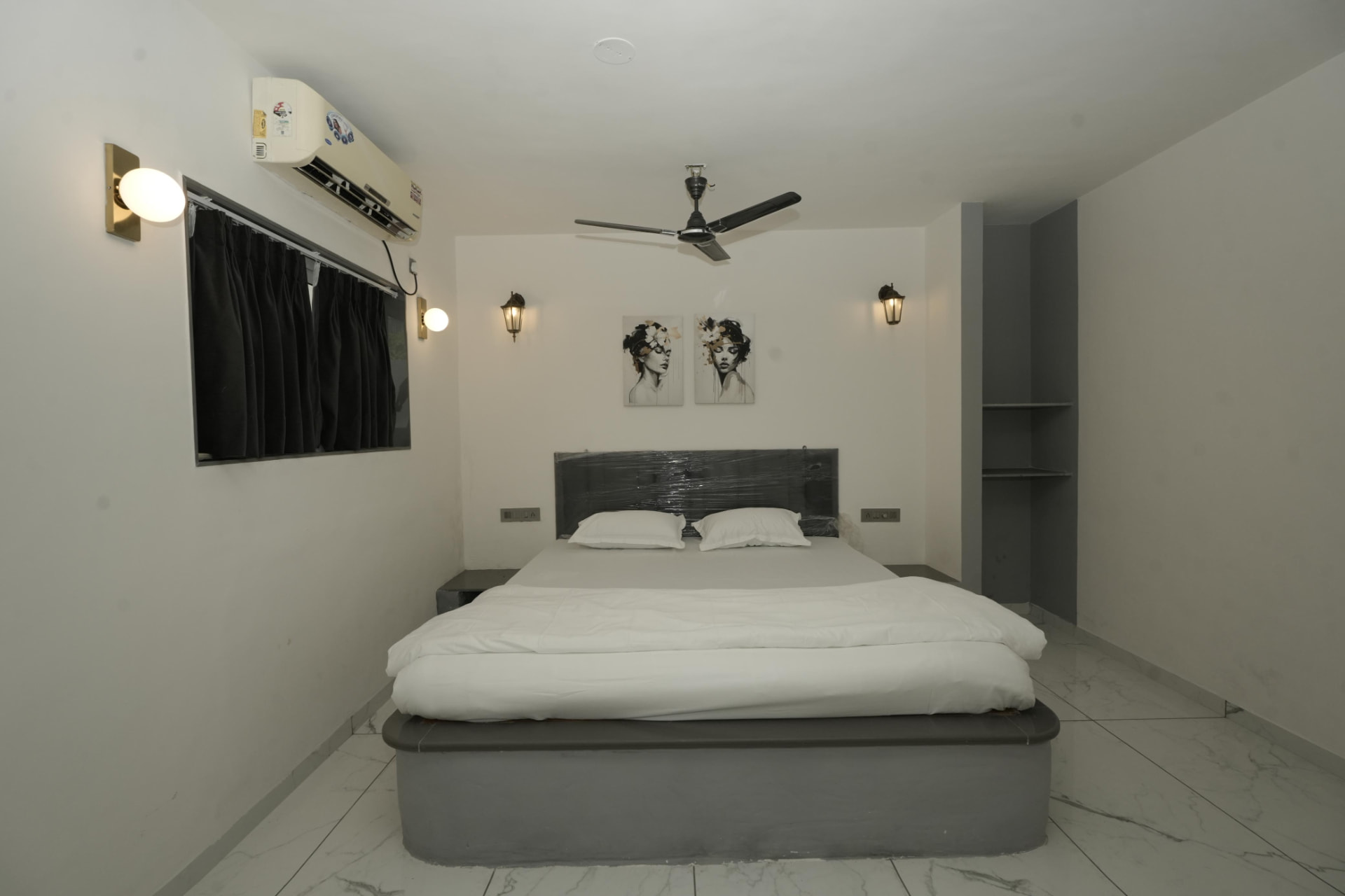King bedroom with grey headboard and marble flooring