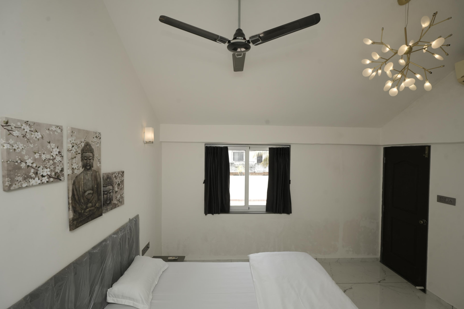 Bright bedroom with Buddha art and vaulted ceiling