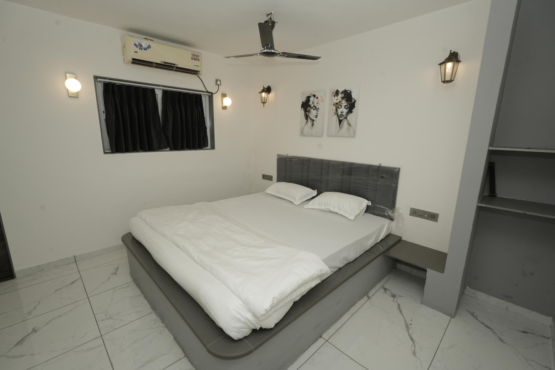 Air-conditioned bedroom with brass wall sconces